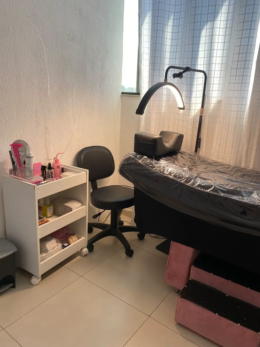 Espaço de atendimento do IF Studio, com maca, iluminação e carrinho de materiais.